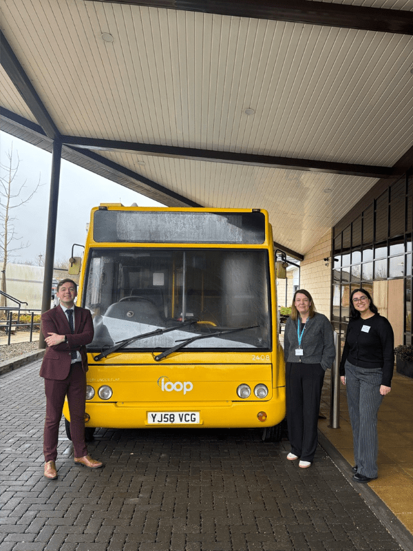 People standing next to yellow bus