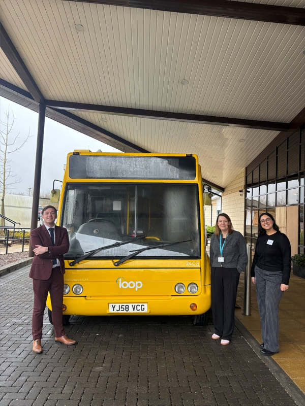 People standing next to yellow bus