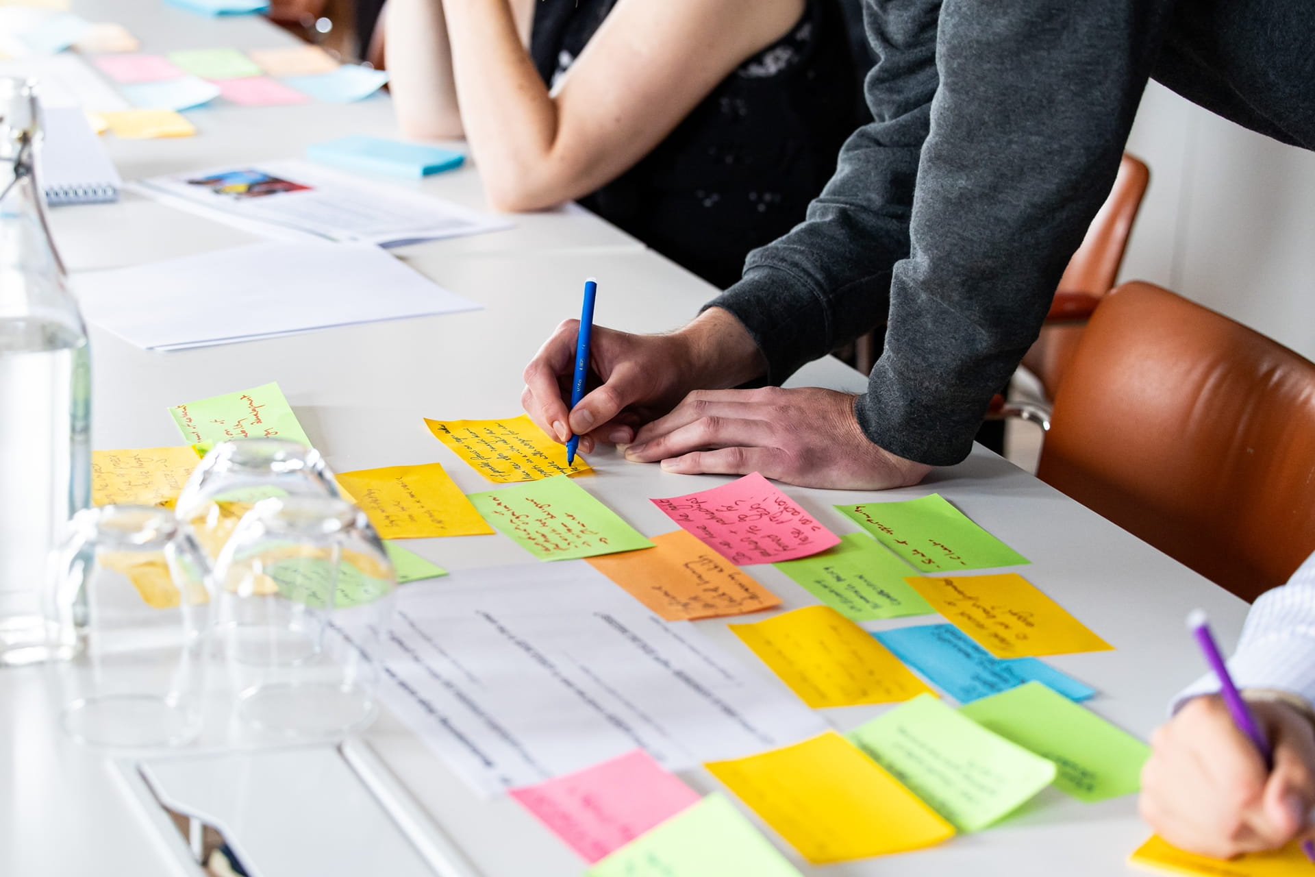 Someone shares their thoughts by writing on a post-it note.